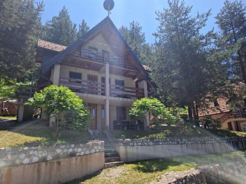 Drvena planinska kuća Vila Borovi na Zaovinama okružena visokim borovima i četinarima