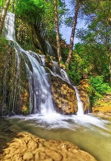 Vodopad na Staroj planini okružen bujnom prirodom i stenama.