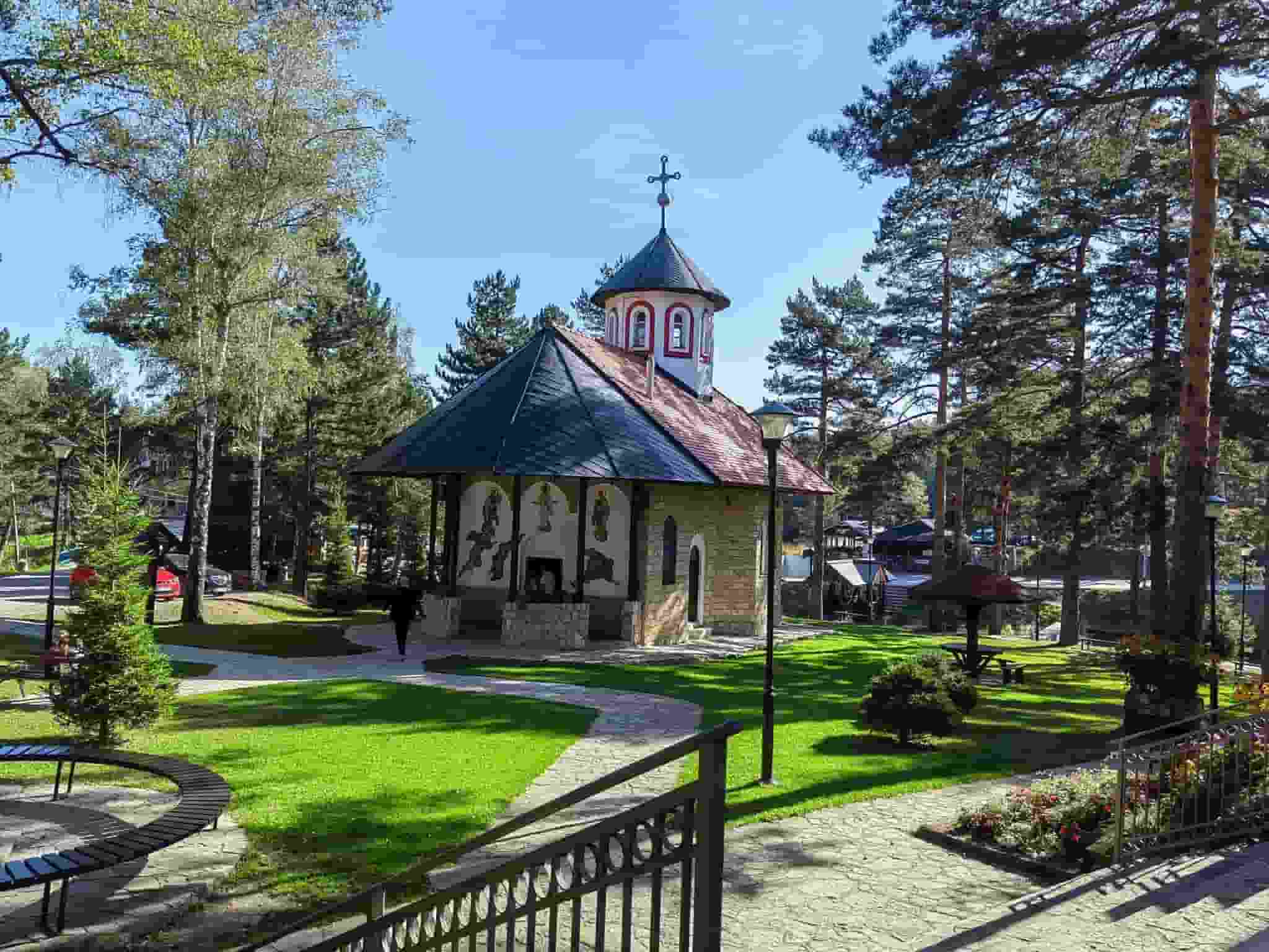 Zeleni planinski pejzaž Divčibara sa borovom šumom i vikendicama.