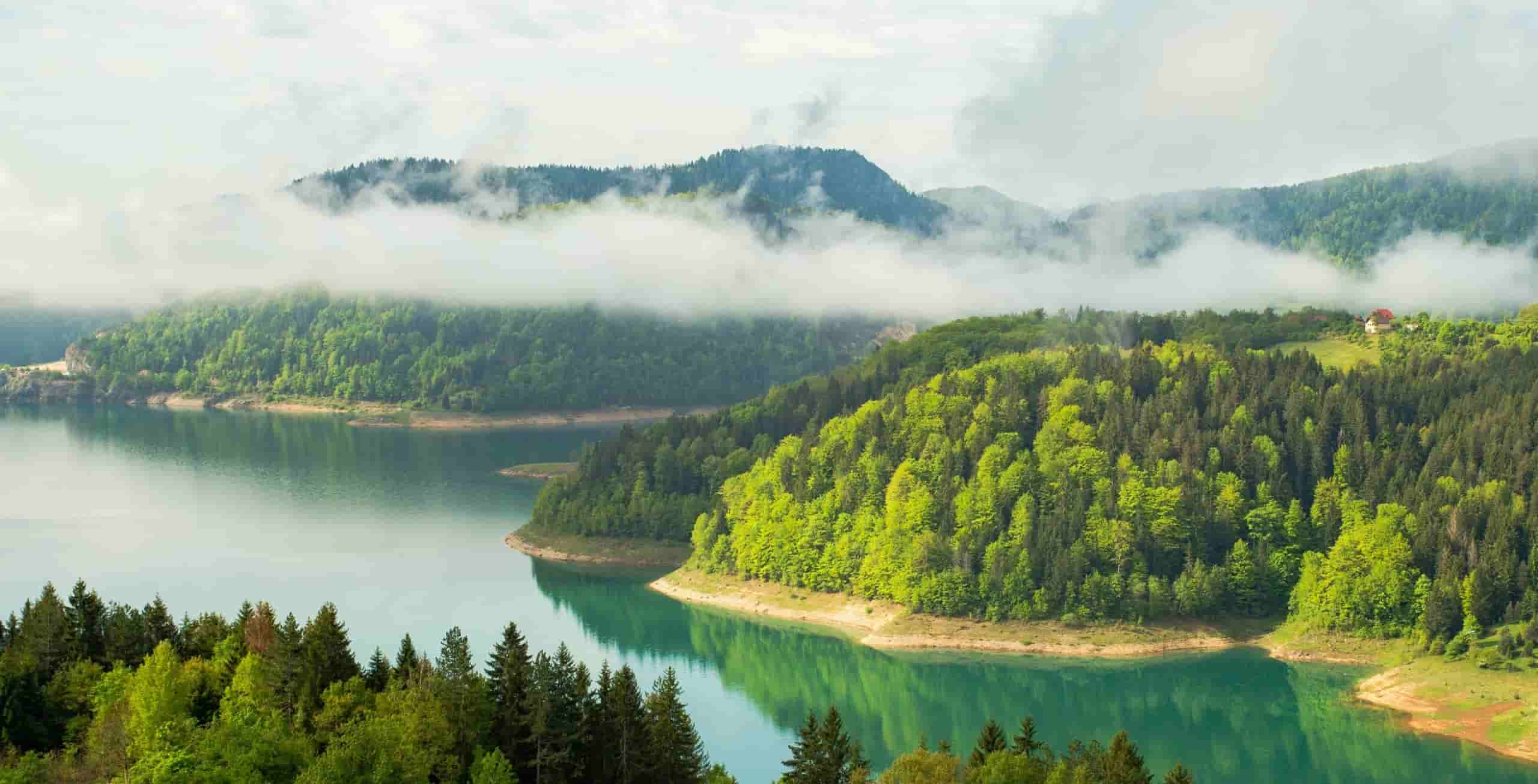Planinsko jezero Zaovine na Tari, okruženo šumom i oblacima.