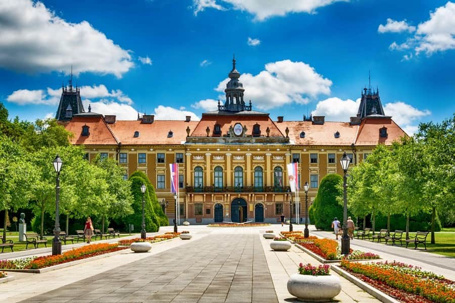 Centar Sombora sa baroknim zgradama i zelenilom, blizu reke Dunav.