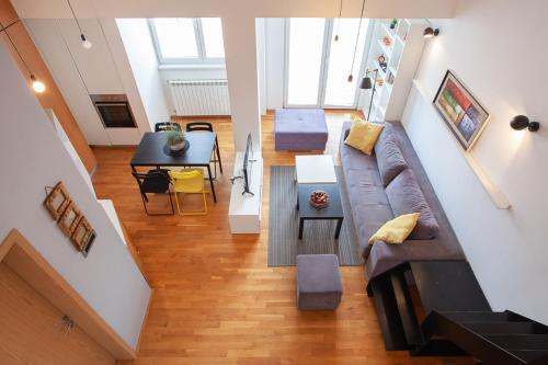 Moderna dnevna soba sa sivom sofom i kuhinjskim ostrvom u Urban Serviced Apartments u Skoplju